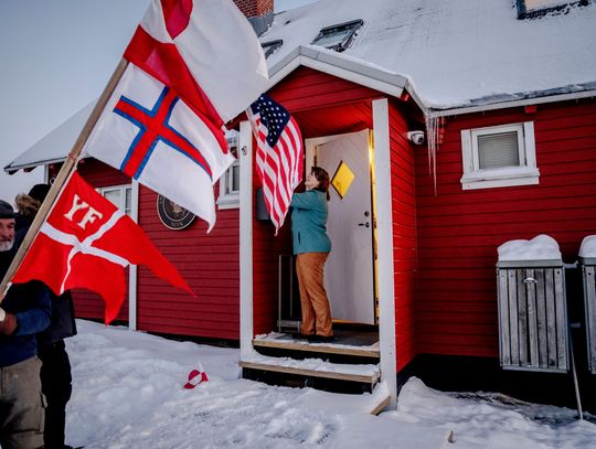 Grenlandczyk protestuje przed konsulatem USA w Nuuk, ma ze sobą polską flagę
