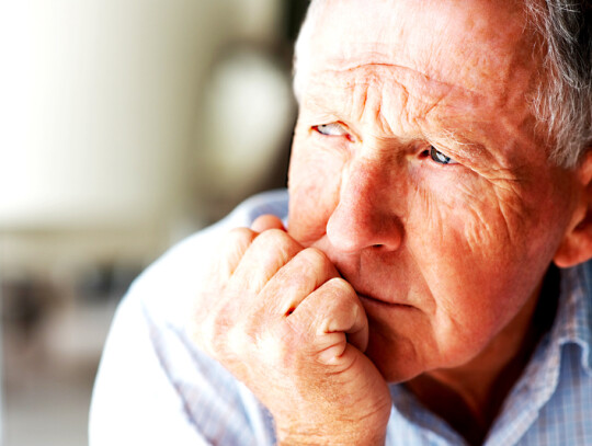 Closeup of a lonely senior man lost in thought , looking away
