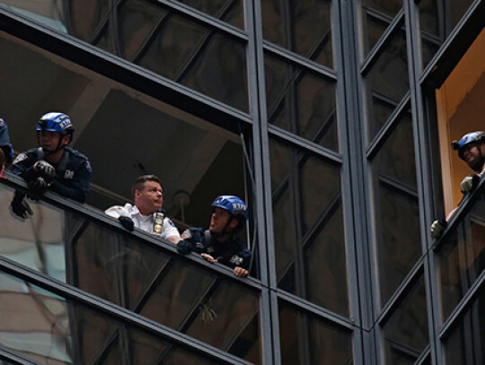 A man climbs Trump Tower in New York City