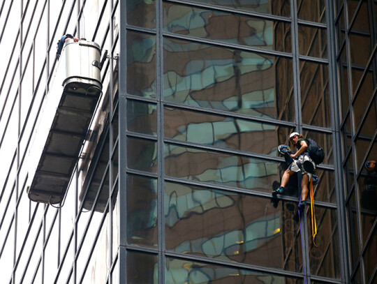 A man climbs Trump Tower in New York City