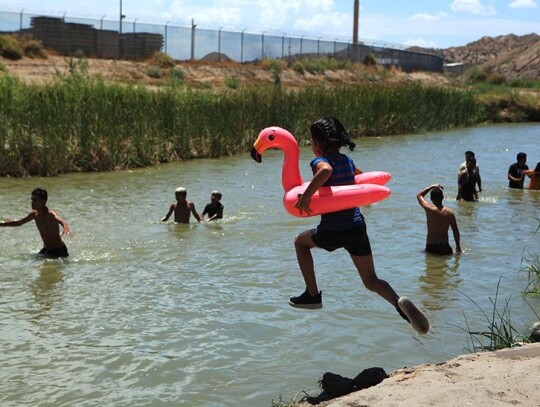 Children and adults cool off in the Rio Grandein Ciudad Juarez, Mexico - 19 Jul 2020