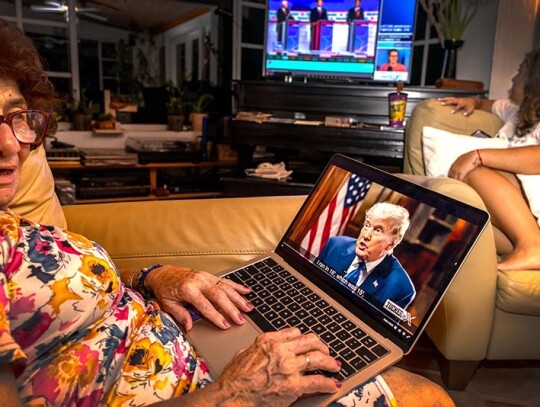 People watch Carlson interview of Trump on the platform 'X', Miami, USA - 23 Aug 2023