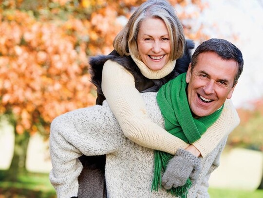 Senior man giving woman piggyback ride