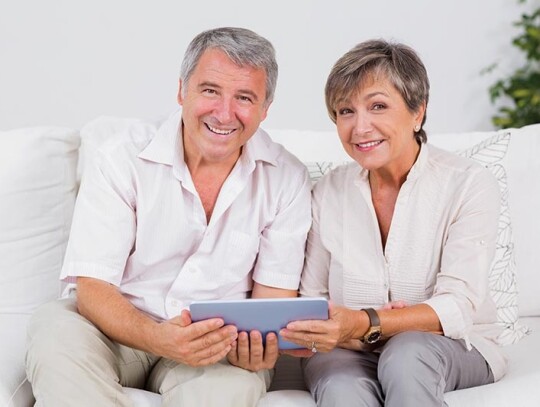 Old couple looking camera with tablet pc in their hands