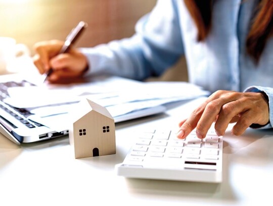 Stressed young woman calculating monthly home expenses